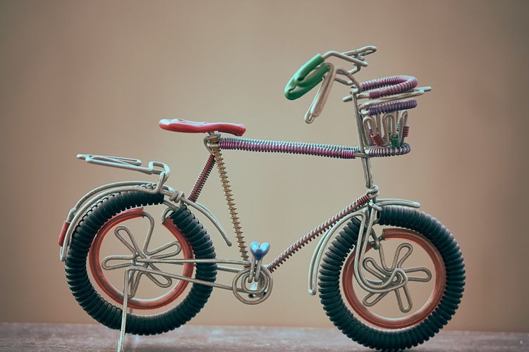 un vélo miniature fabriqué avec des éléments de récupération comme des ressorts, des fils en métal...
